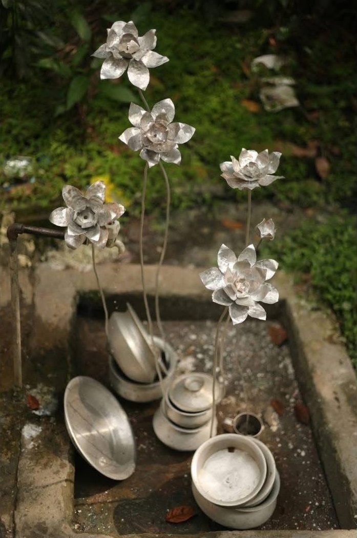 Aluminium lotus flowers on steel stems rising from stacked cooking pots
